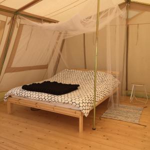 een slaapkamer met een bed in een tent bij VierVaart Tent in Groede