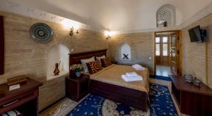 Кровать или кровати в номере Orient Star Khiva Hotel- Madrasah Muhammad Aminkhan 1855 +37 фотографий