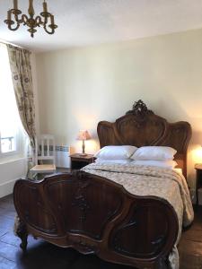 a bedroom with a large wooden bed with white pillows at Domus Dulcis in Ribérac