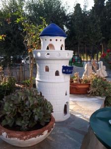 a white bird house sitting next to a potted plant at Margarita Studios in Parikia
