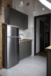 a kitchen with a stainless steel refrigerator and gray cabinets at Apartament Przy Rynku in Opole