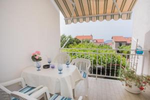 a white table and chairs on a balcony at Apartmani Branko Lemac in Brodarica
