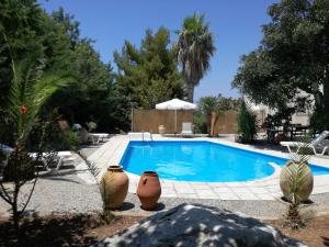 a swimming pool with three vases sitting next to it at Villa Irene in Kos