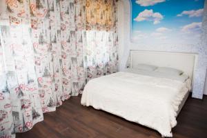 een slaapkamer met een wit bed en een gordijn bij Apartment Kristall at Leningradskaya 46 in Yurga