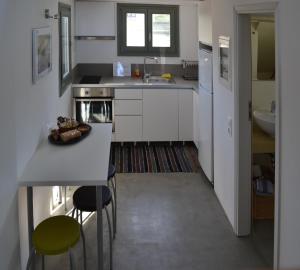 a kitchen with white cabinets and a sink and a table at Sea Shelter in Koundouros