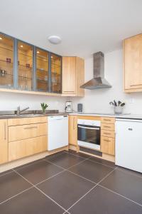 a kitchen with wooden cabinets and white appliances at Gränna Lakeview in Gränna