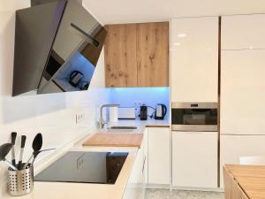 a kitchen with white appliances and wooden cabinets at Apartamento moderno nautilus (Playa Capellans) in Salou