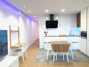a kitchen with a table and chairs and a tv at Apartamento moderno nautilus (Playa Capellans) in Salou