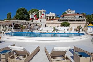 a pool with chairs and a building in the background at Arcadia VIP-apartments in Golfstream in Odesa