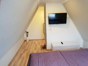 a bedroom with a bed and a flat screen tv at Ferienhaus Sonneck in Klockenhagen