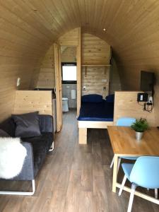 a living room of a tiny house with a couch and a table at Camping Ginsterveld in Burgh Haamstede