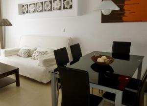 sala de estar con mesa y sofá en Apartamento con piscina, en Garrucha