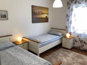 2 Einzelbetten in einem Zimmer mit 2 Lampen in der Unterkunft Ferienwohnung "Am Nordertor" in Flensburg