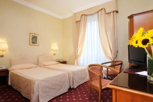 a hotel room with two beds and a window at Hotel Torino in Rome