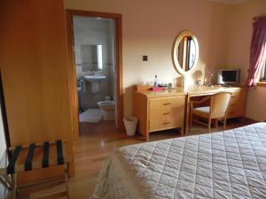 a bedroom with a bed and a bathroom with a sink at Shelmalier House in Athlone