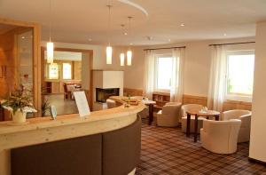 ラグンドにあるHotel Floraのホテルのロビーにはバー、テーブル、椅子があります。