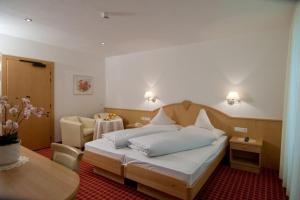 a bedroom with a bed and a living room at Hotel Flora in Lagundo +55 photos