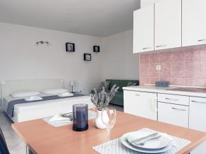 a kitchen and dining room with a table and a bed at Apartments Saric 2 in Jadrija