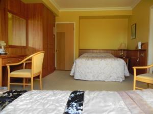 a bedroom with two beds and two chairs at Shelmalier House in Athlone