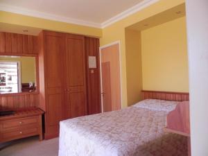 a bedroom with a bed and a wooden cabinet at Shelmalier House in Athlone