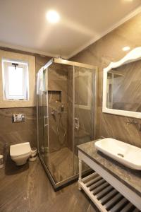 a bathroom with a shower and a toilet and a sink at Grand Alaçatı Butik Hotel in Alaçatı