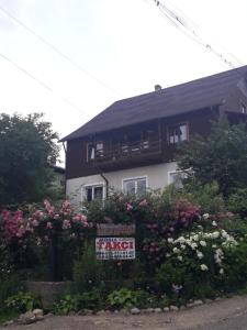 a sign in front of a house with flowers at Sadyba Ellada in Yaremche