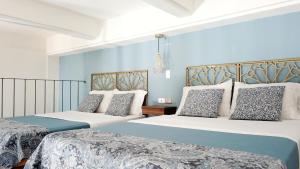 two beds in a room with blue walls at Soy Local Centro Histórico in Cartagena de Indias