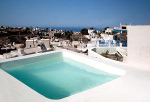 a swimming pool on the roof of a house at Villa Del Sol Santorini in Mesaria