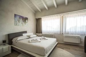 ein Schlafzimmer mit einem großen Bett und einem Fenster in der Unterkunft Relais Madergnago Gardapartments in Desenzano del Garda