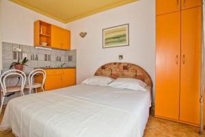 Schlafzimmer mit großem Bett und orangefarbenen Schränken in der Unterkunft Apartments Sijerkovic in Herceg-Novi