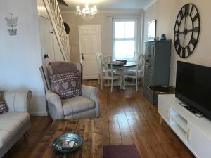 a living room with a couch and a table at Rosebud cottage in Corton