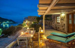 a patio with a table and chairs at night at Theologos Houses in Grikos