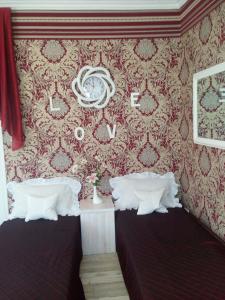 a bedroom with two beds and a wall with wallpaper at Guest House Comfort in Kherson