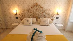 a bedroom with a white bed with a headboard at Conte di Morelia in Salerno