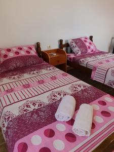 a room with two beds with pink and white sheets at Guest house Sjekloća in Bar