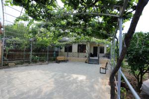 a patio with a bench and a house at Papazo in Kutaisi