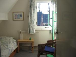 a bedroom with a bed and a window and a table at B&B De Esdoorn in Norg