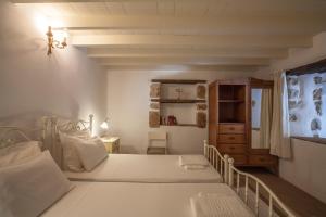 a bedroom with a large white bed and a window at Theologos Houses in Grikos