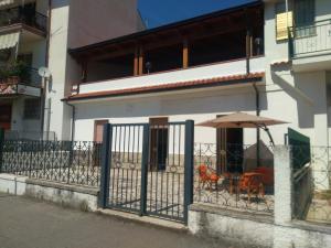 budynek z ogrodzeniem, parasolem i stołami w obiekcie Mary&Bi w mieście Scalea