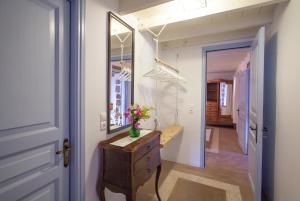 a hallway with a vase of flowers on a dresser and a mirror at Theologos Houses in Grikos