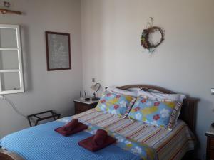 1 dormitorio con 1 cama con 2 zapatillas rojas en Villa Perivoli, en Platis Yialos Sifnos
