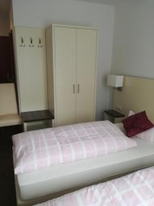 a bedroom with a large bed and a white cabinet at Zeesener Gasthof in Königs Wusterhausen
