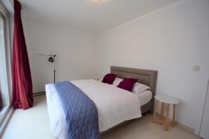 a bedroom with a bed and a table in it at ABC Apartment Langestraat in Blankenberge