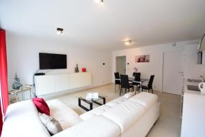 a living room with a white couch and a table at ABC Apartment Langestraat in Blankenberge