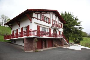 a large house with red balconies on the side of it at Gure Lana in Saint-Jean-Pied-de-Port