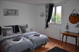 1 dormitorio con 2 camas y ventana en Gîte Brin de Campagne, en Vaucremont