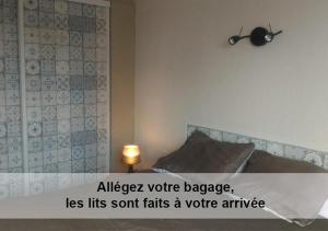 a bedroom with a bed with a sign on the wall at Au cèdre bleu in Saint-Martin-Boulogne