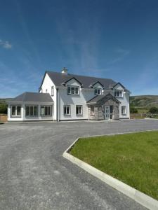 una gran casa blanca con entrada en Burren Rock Farmhouse B&B, en Turlough