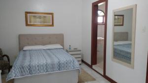 een slaapkamer met een bed en een spiegel bij London House in São José