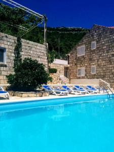 un grupo de sillas azules sentadas en una piscina en Apartments Anamaria en Dubrovnik